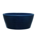 Blue ceramic bowl with textured surface on a light gray background